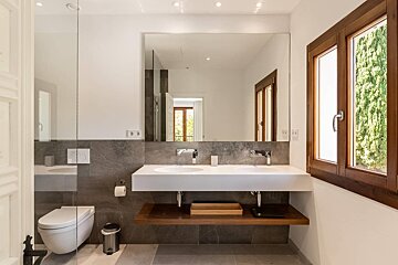 A bathroom with two sinks and a toilet