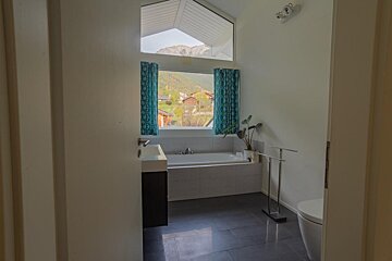A bathroom with a tub and a window with mountains in the background