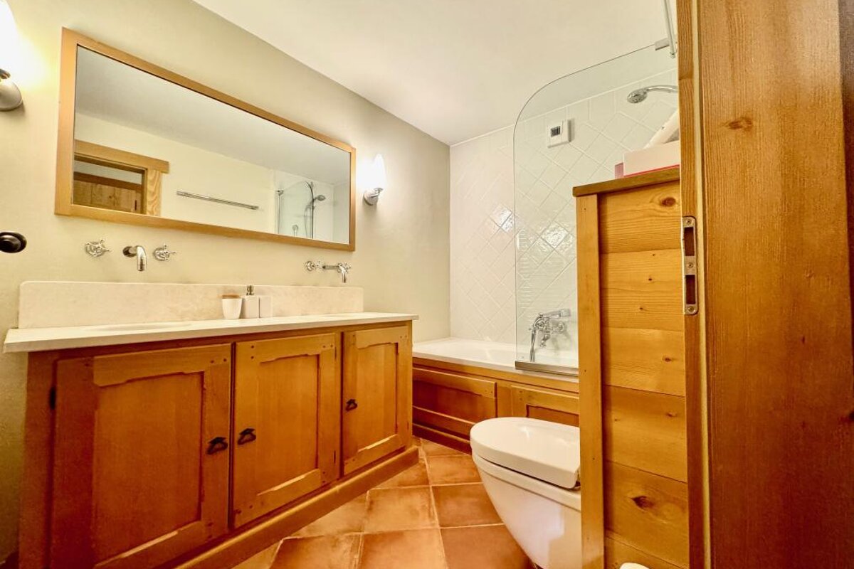 A bathroom with wooden cabinets and a toilet