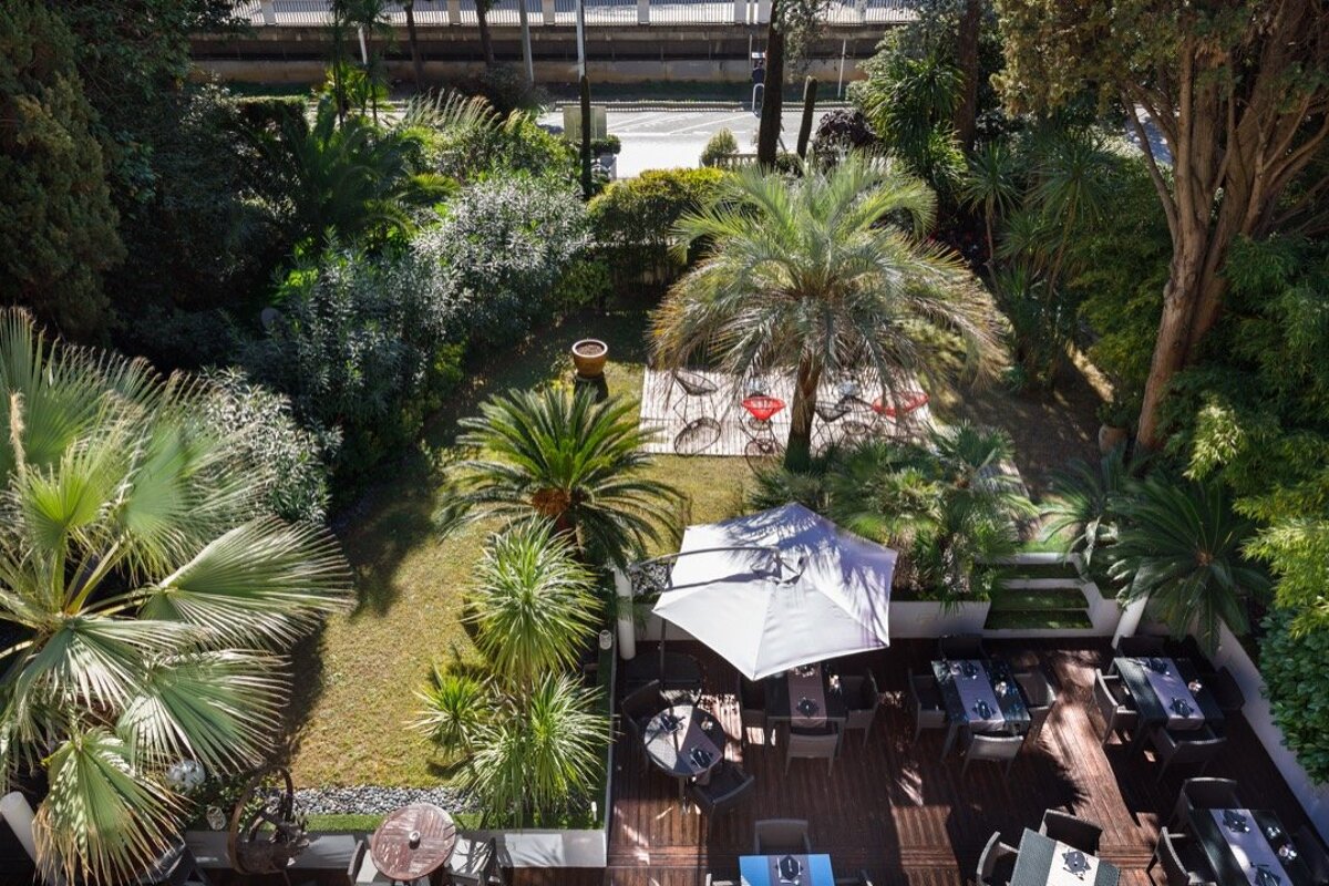 An aerial view of a garden with tables and umbrellas
