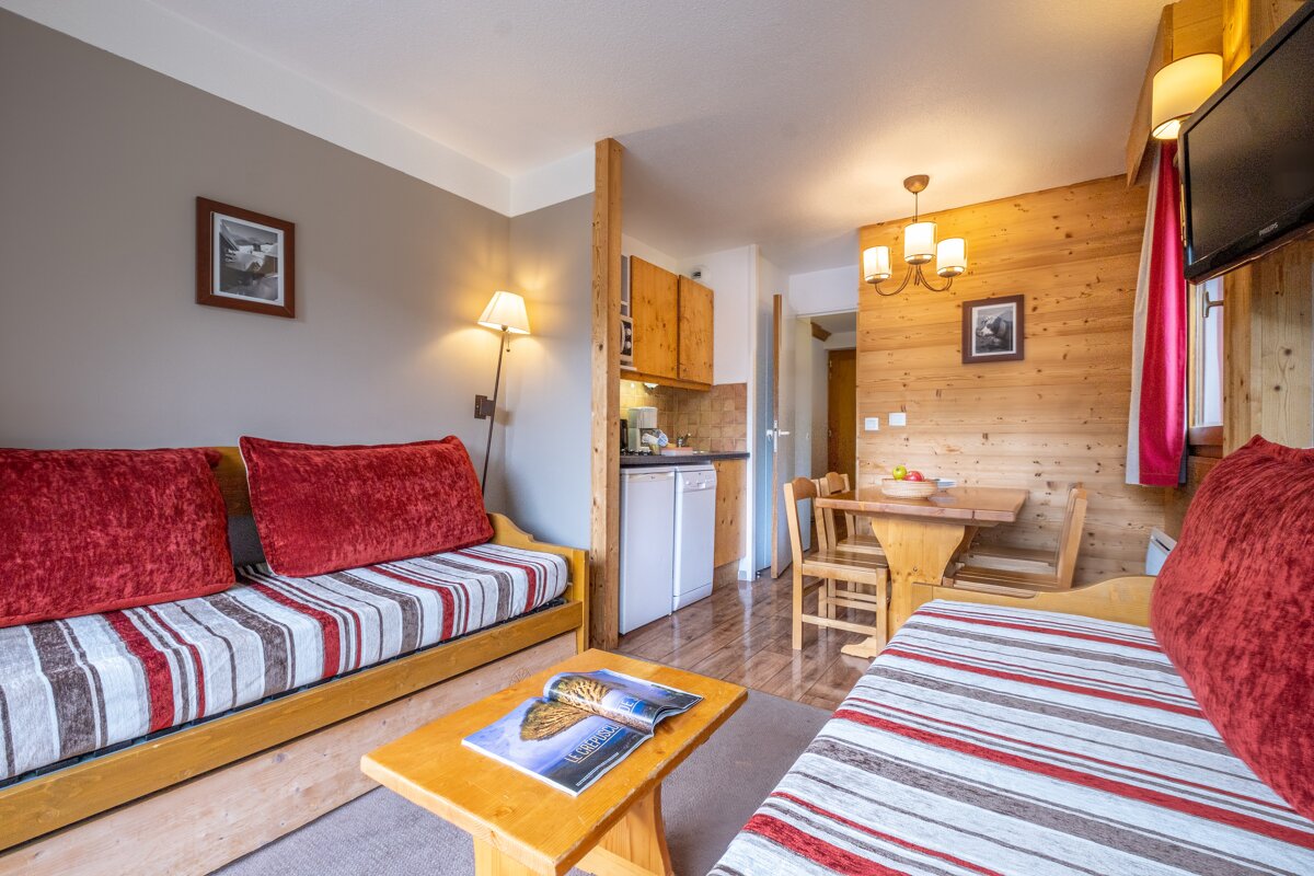 A living room with a couch and a table with a magazine on the coffee table