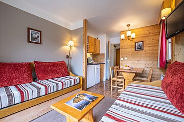 A living room with a couch and a table with a magazine on the coffee table