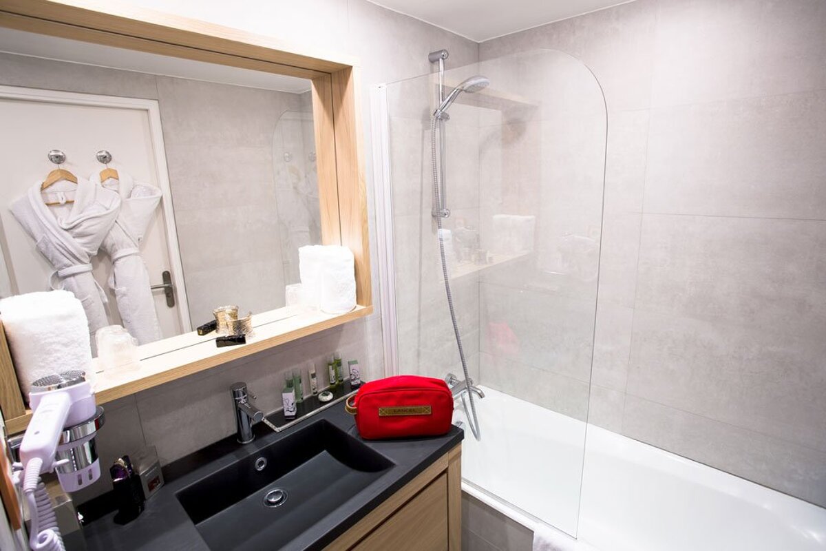 A bathroom with a black sink and a red cosmetic bag
