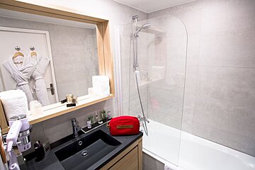 A bathroom with a black sink and a red cosmetic bag