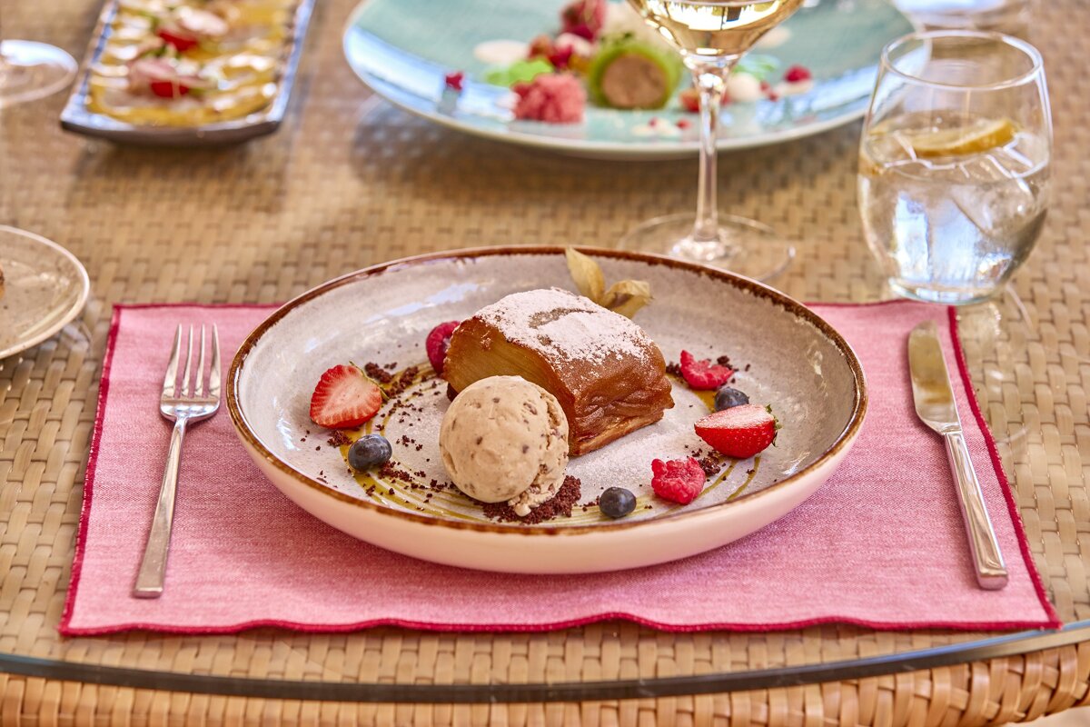 A plate of dessert with ice cream and strawberries on a table