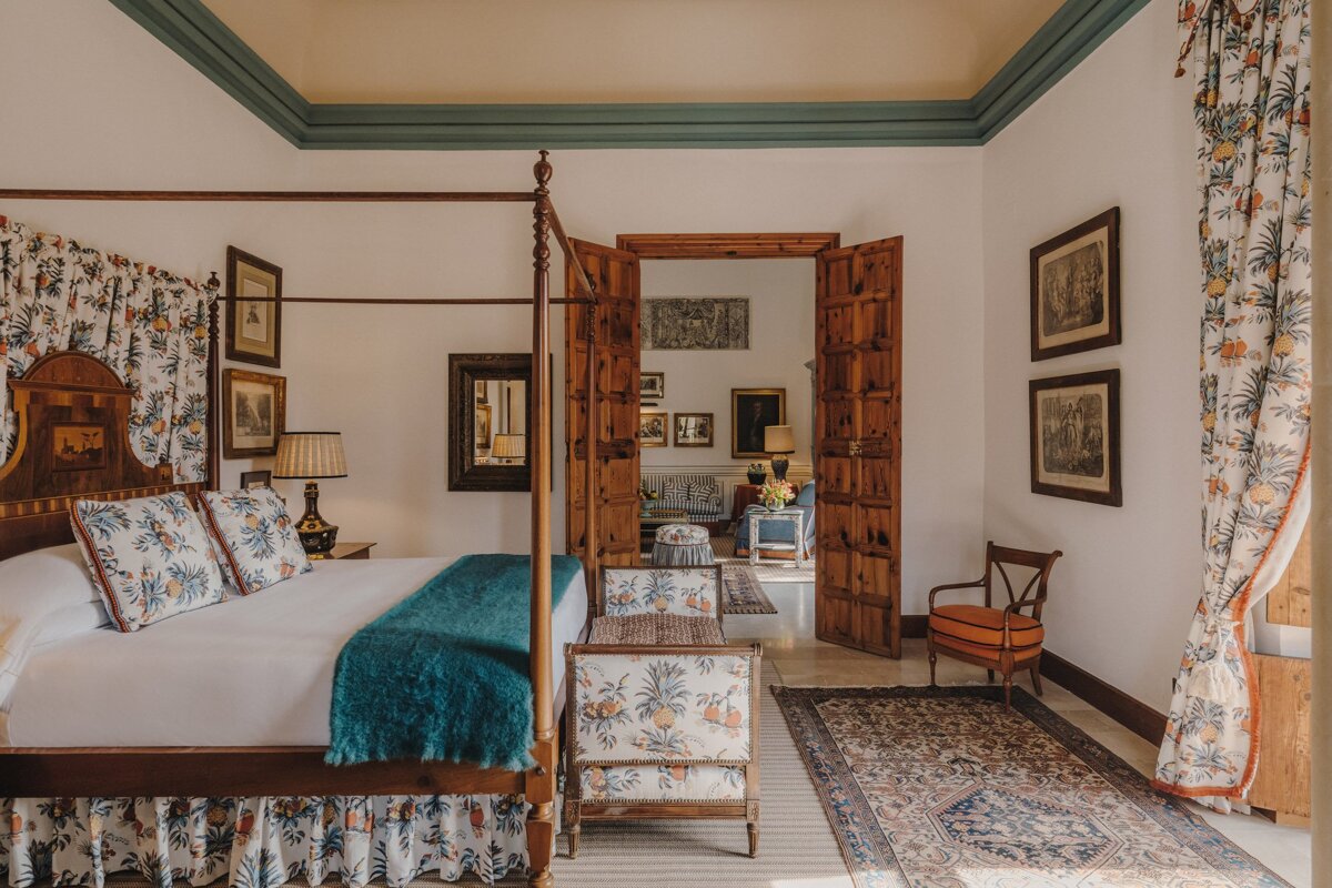 A bedroom with a four poster bed and a rug