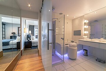 A bathroom in a hotel with a bathtub and shower