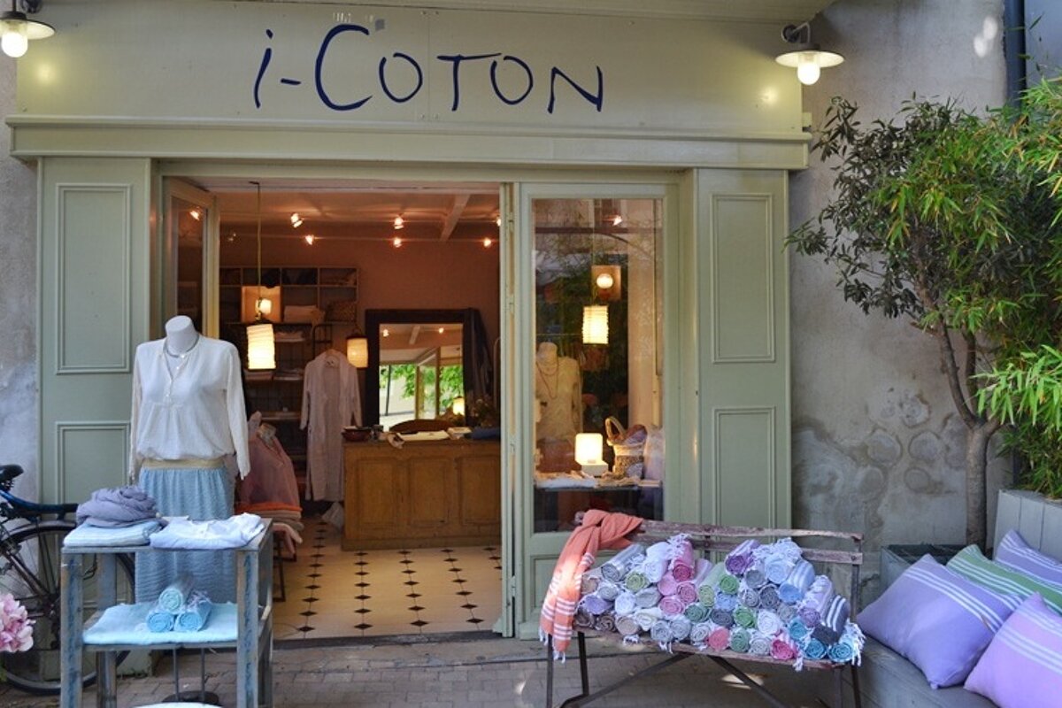image of i-coton shop front with a mannequin and towels out the front and the windows open looking inside