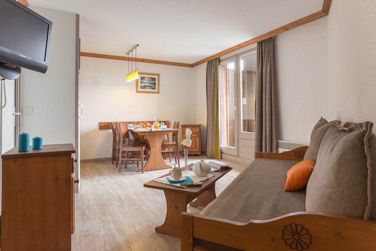 A living room with a couch a table and a television