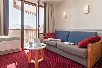 A living room with a couch and a table with a laptop on it