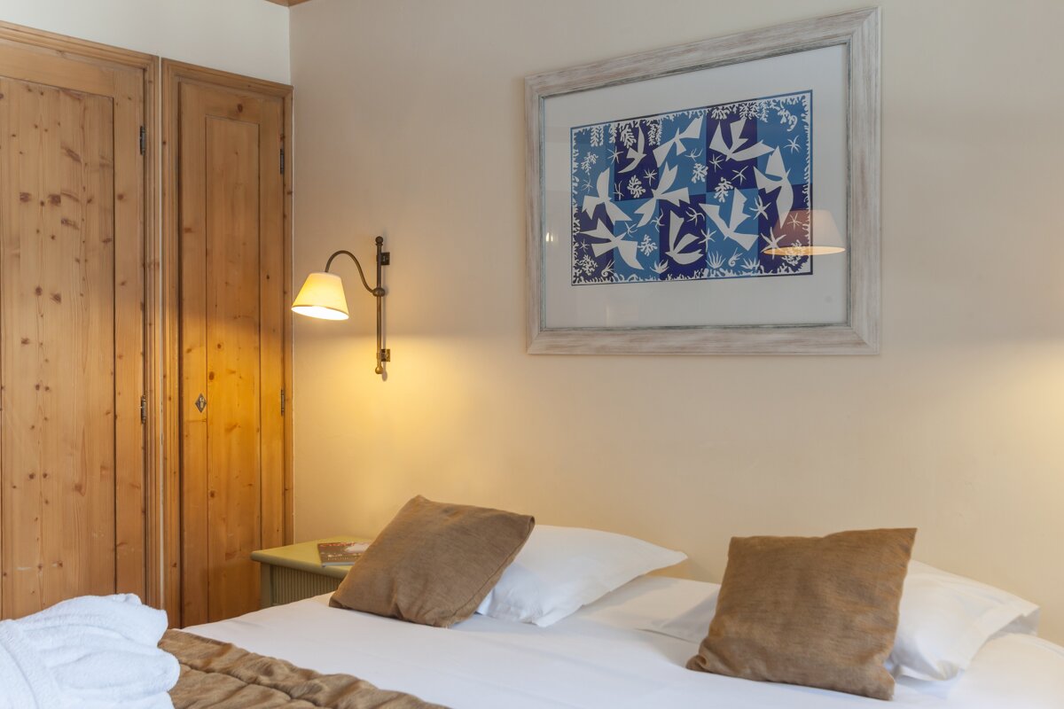 A bedroom with a picture on the wall above the bed