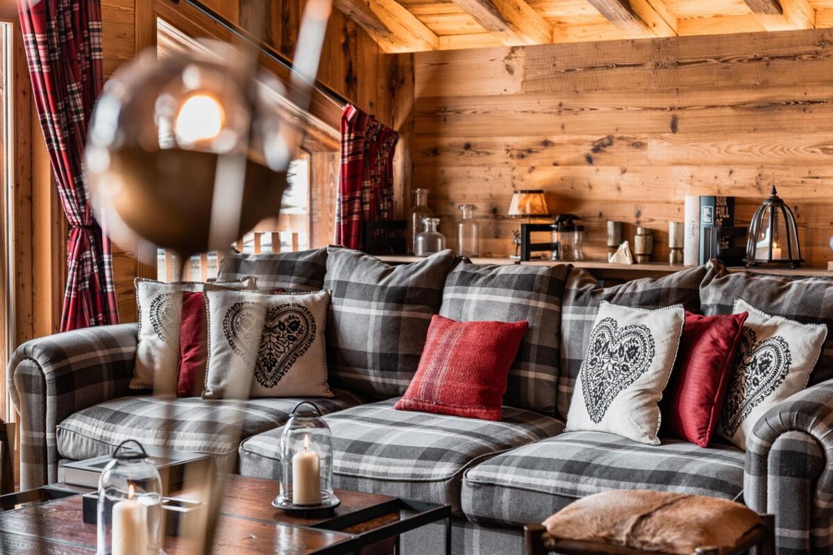 A plaid couch with hearts on the pillows