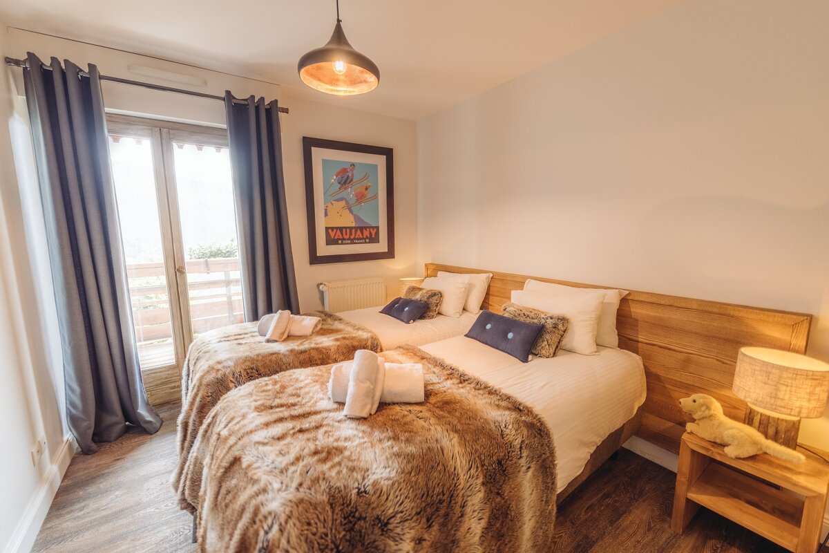 A bedroom with two beds and a picture on the wall that says vaubany