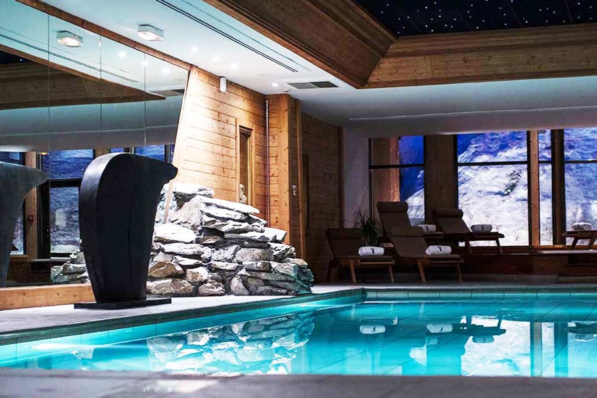 A large indoor swimming pool with a penguin statue in the foreground