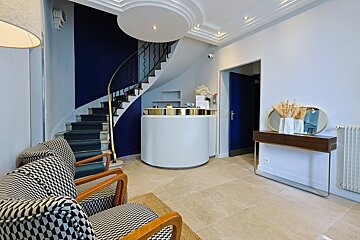 A waiting room with a staircase and a reception desk
