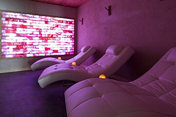 Two lounge chairs in front of a pink wall