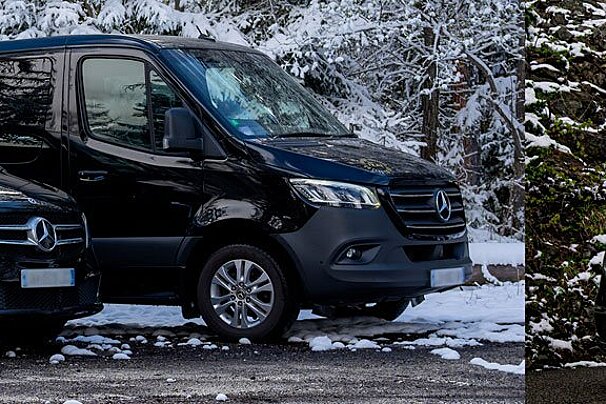 A black mercedes van is parked in the snow