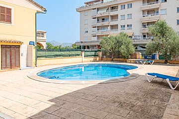 A swimming pool in front of a building with a sign that says ' piscina ' on it