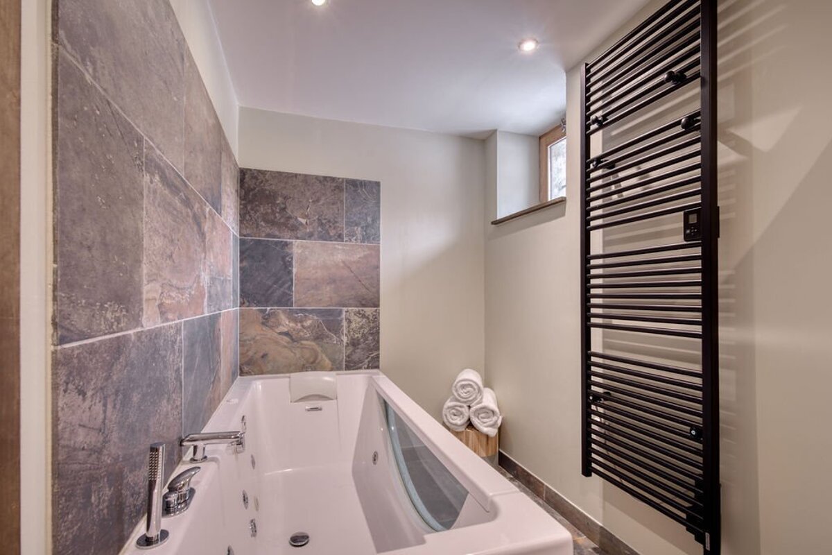 A bathroom with a bathtub and a towel rack