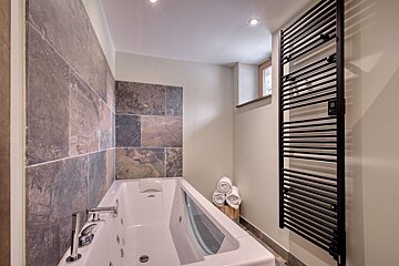 A bathroom with a bathtub and a towel rack