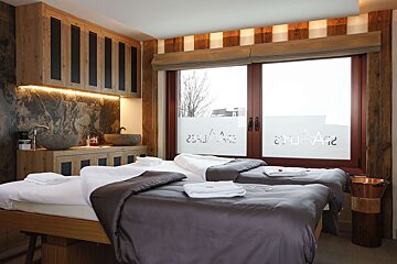 Two beds in a room with a window that says ' a ' on it