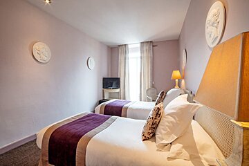 A hotel room with two beds and a flat screen tv