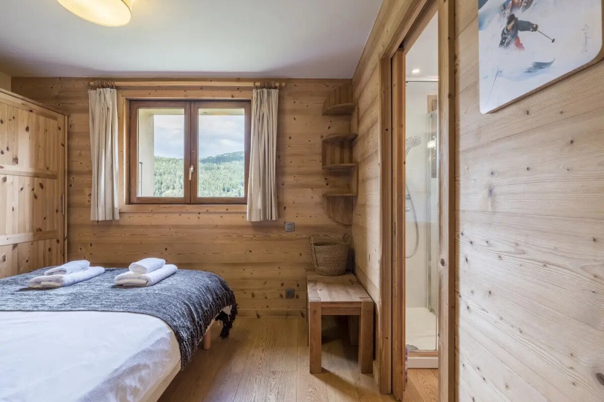 A wooden bedroom with a bed and a window