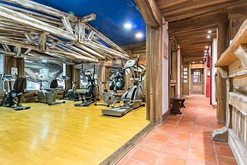 A gym with a blue ceiling and wooden beams