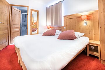 A hotel room with a bed and a mirror