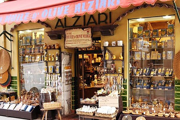 A store front with a red awning that says alziari