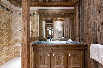 A bathroom with wooden cabinets and a sink