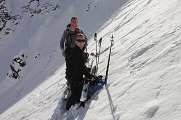 2 men with skis taking a break on a ski tour