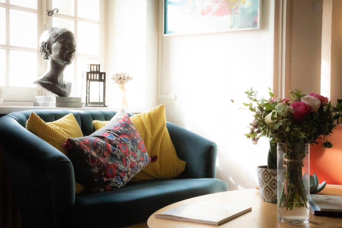A living room with a couch and a vase of flowers