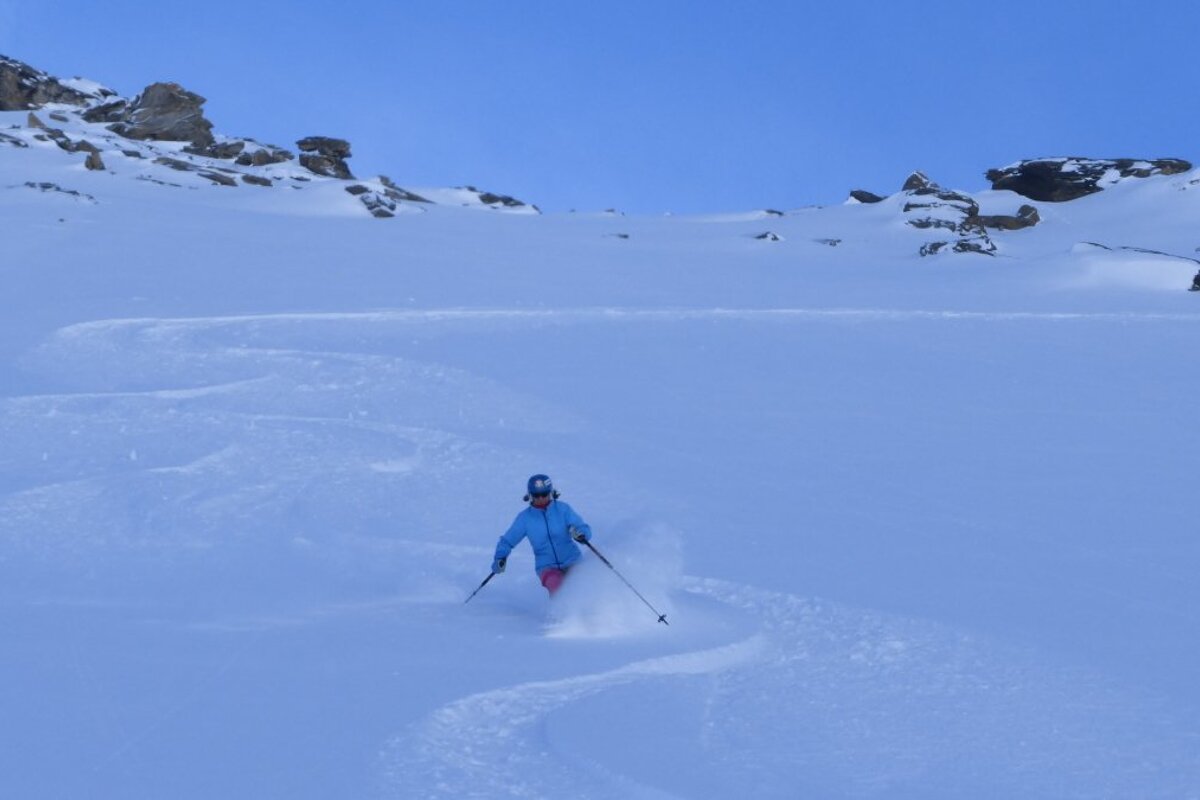 a skier in a blue jacket