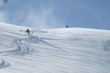 skiers coming over a ridge