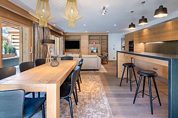 A dining room with a long wooden table and chairs