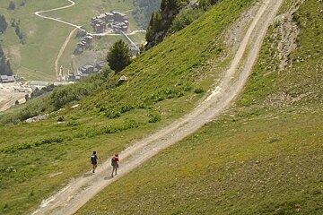 two people hiking on a trail in meribel