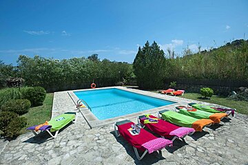 A swimming pool surrounded by lawn chairs and a life preserver