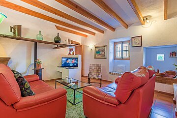 A living room with two red couches and a flat screen tv