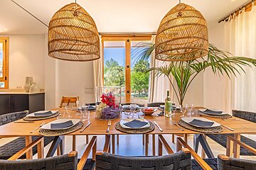 A dining room table with a bottle of wine on it