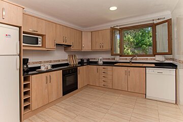 A kitchen with wooden cabinets and a white lg refrigerator