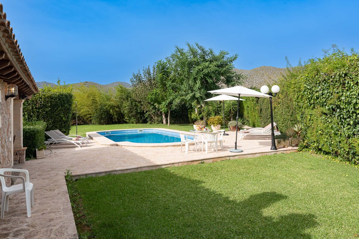 A large swimming pool is surrounded by chairs and umbrellas