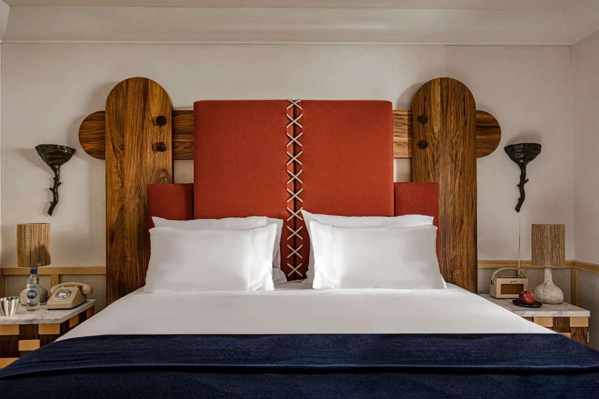 A bed with a red headboard and white pillows