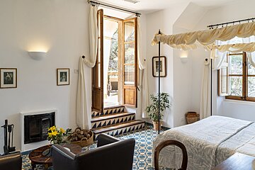 A bedroom with a canopy bed and a fireplace