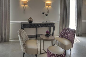 Two chairs and a table with a vase of flowers on it