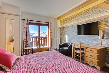 A bedroom with a large bed and a flat screen tv