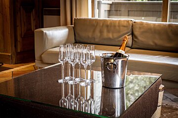 A bucket of champagne sits on a table next to a couch