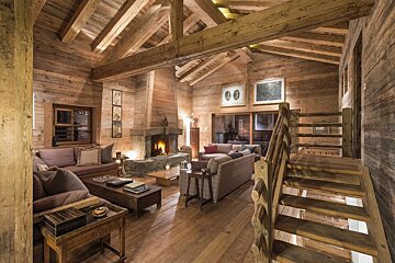 A living room with a fireplace and stairs leading up to the second floor