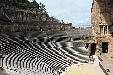 A group of people are standing in an ancient amphitheater