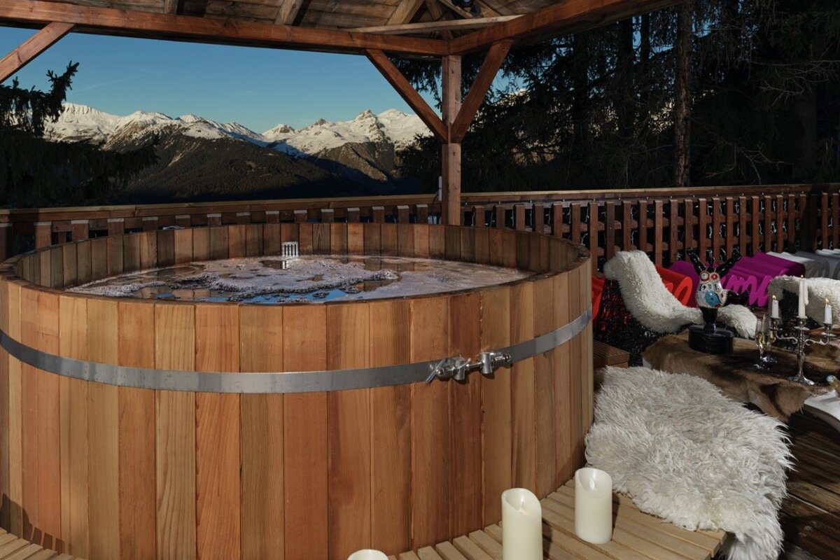 A wooden hot tub with a view of the mountains